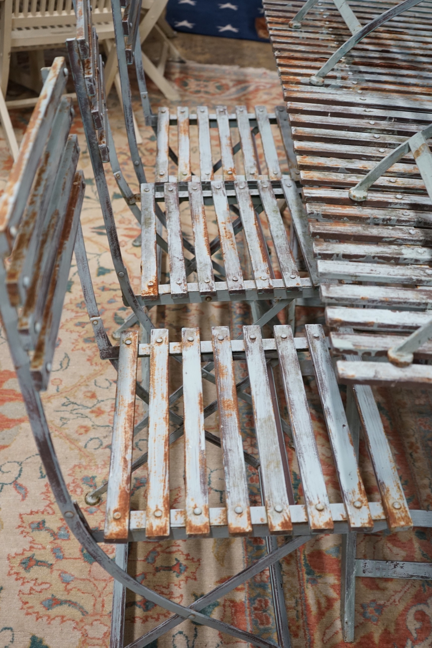 A pair of rectangular painted metal slatted garden tables, each width 86cm, depth 87cm, height 74cm and six matching folding chairs